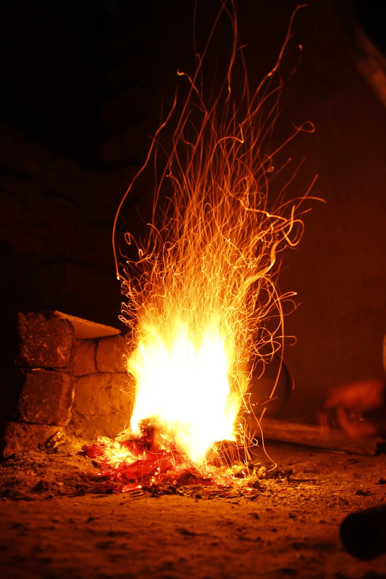 A striking image of a campfire at night with dynamic sparks flying, creating a warm ambiance.