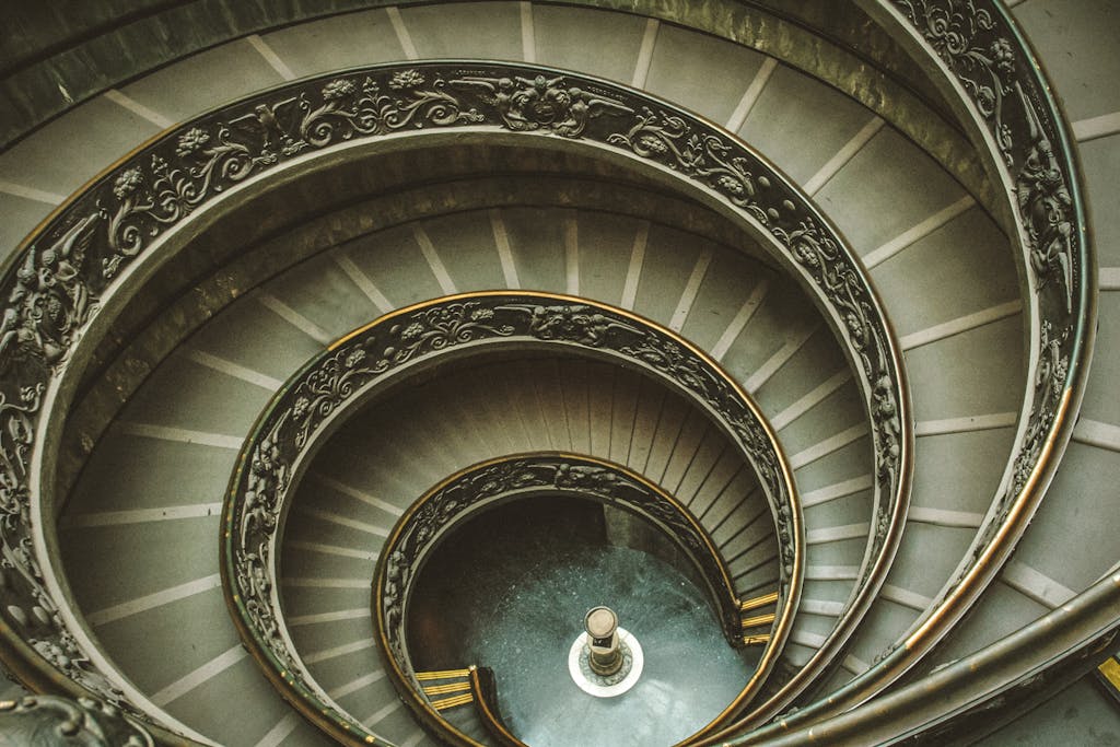 Intricate spiral staircase with ornate handrails in Vatican Museums, Rome, Italy.