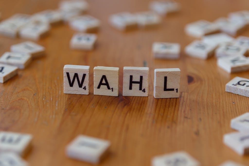 Scrabble letter tiles forming 'WAHL' on a wooden table, close-up view.