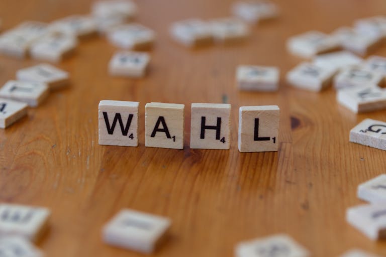 Scrabble letter tiles forming 'WAHL' on a wooden table, close-up view.